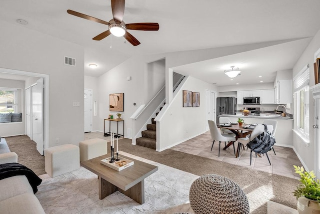 6906 Tesoro Trl, Austin, TX 78729 - living area featuring light carpet, stairs, vaulted ceiling, ceiling fan, and baseboards