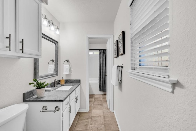6906 Tesoro Trl, Austin, TX 78729 - bathroom featuring vanity, toilet, healthy amount of natural light, baseboards, and a textured wall