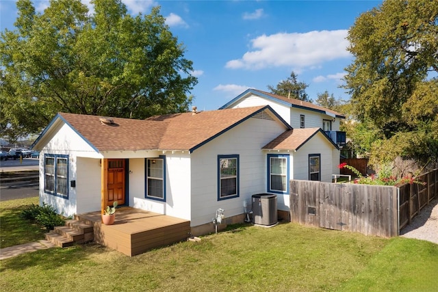 back of house with fence, a lawn, a shingled roof, and central air condition unit