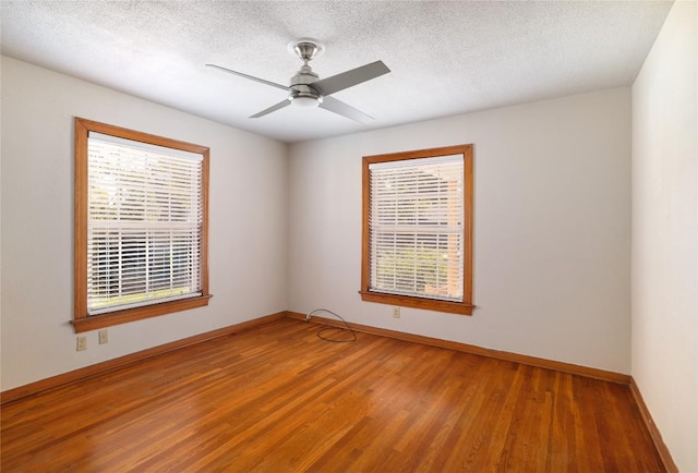 unfurnished room with baseboards, a healthy amount of sunlight, and wood finished floors