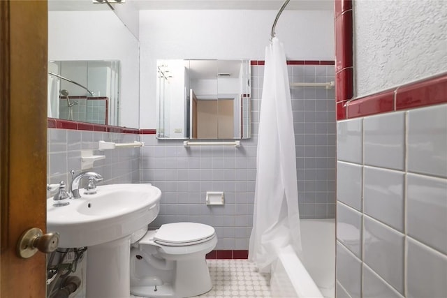 full bath with tile walls, shower / tub combo with curtain, and toilet