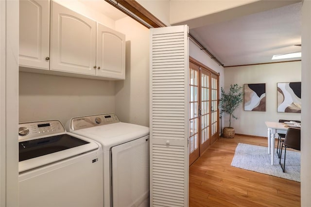 washroom with light wood-style flooring, french doors, baseboards, cabinet space, and washer and dryer