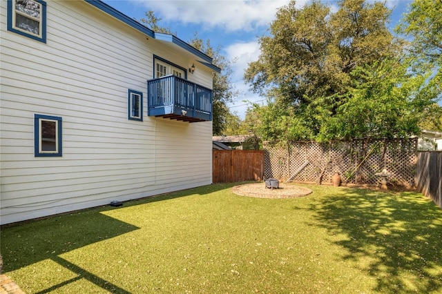 view of yard with a fenced backyard and a balcony