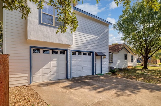 exterior space featuring concrete driveway, cooling unit, and a garage