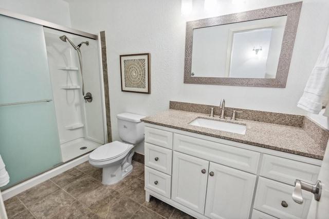 full bath with toilet, vanity, and a stall shower
