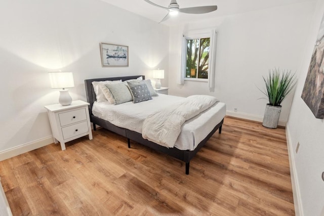 bedroom featuring light wood-type flooring, a ceiling fan, and baseboards
