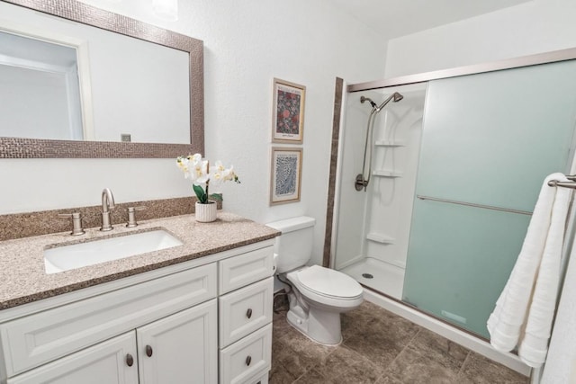 full bath with toilet, vanity, and a stall shower