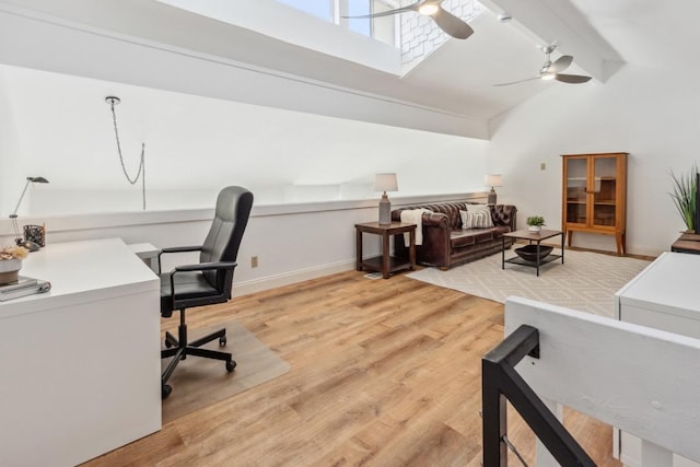office area featuring light wood-style floors, beam ceiling, baseboards, high vaulted ceiling, and ceiling fan