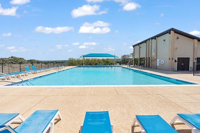pool with a patio and fence