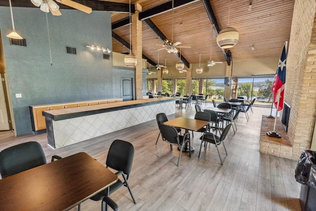 dining space featuring light wood-style flooring, visible vents, beamed ceiling, a ceiling fan, and high vaulted ceiling