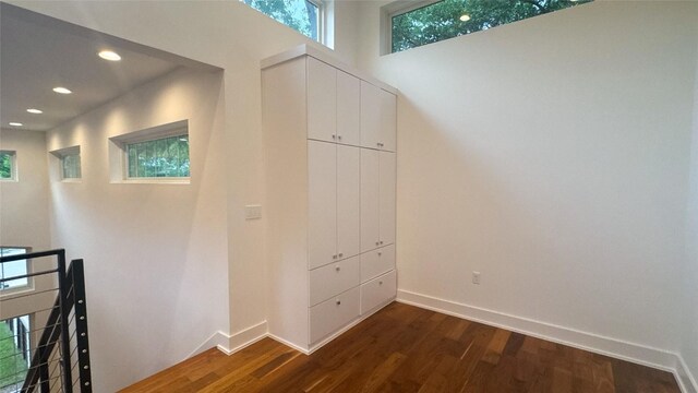 hallway featuring baseboards, recessed lighting, and dark wood-type flooring