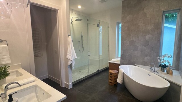 bathroom featuring a freestanding bath, a sink, double vanity, and a stall shower
