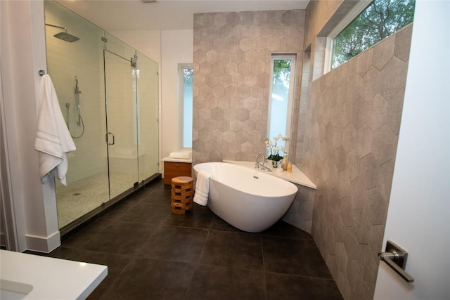 full bath featuring a shower stall, vanity, tile walls, a freestanding bath, and tile patterned flooring