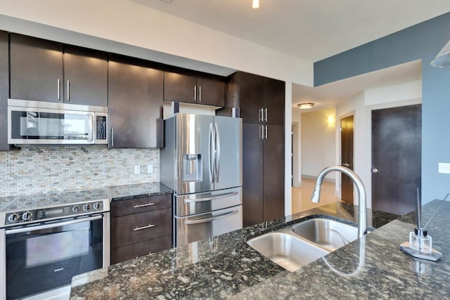 1320 Robert Browning St Unit 409, Austin, TX 78723 - kitchen featuring stainless steel appliances, a sink, dark brown cabinets, backsplash, and dark stone countertops