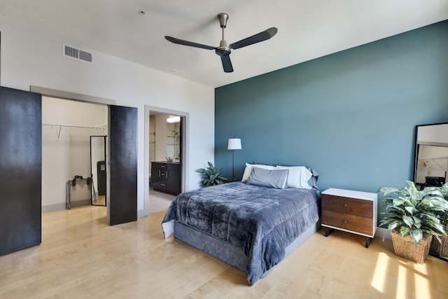 1320 Robert Browning St Unit 409, Austin, TX 78723 - bedroom with light wood-style floors, a ceiling fan, and ensuite bathroom