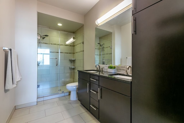 1320 Robert Browning St Unit 409, Austin, TX 78723 - bathroom featuring a shower stall, double vanity, toilet, tile patterned floors, and baseboards