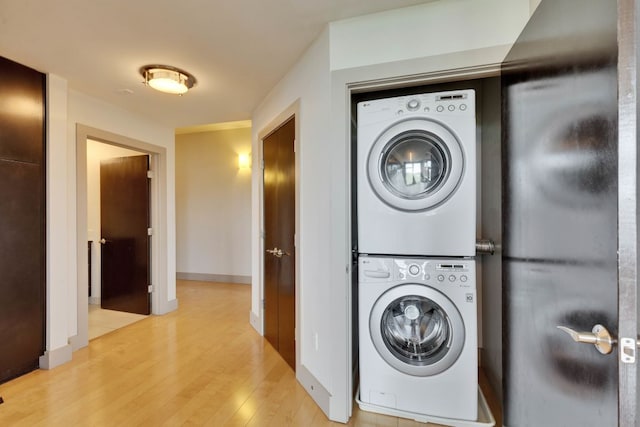 1320 Robert Browning St Unit 409, Austin, TX 78723 - washroom featuring estacked washer and dryer, light wood-style floors, and baseboards
