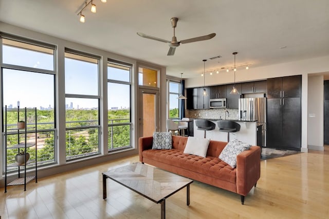 1320 Robert Browning St Unit 409, Austin, TX 78723 - living area with track lighting, a ceiling fan, and light wood-style flooring