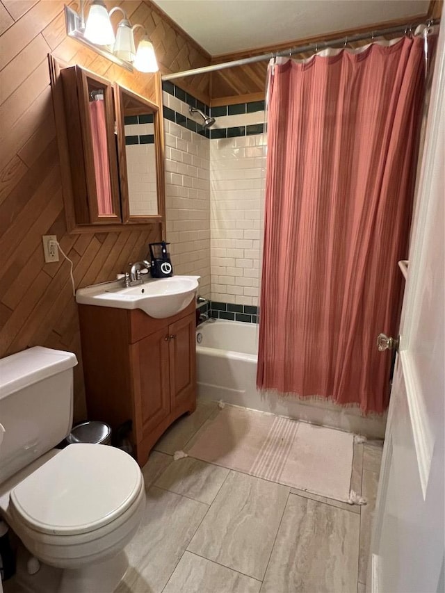 full bathroom with toilet, vanity, wood walls, and shower / bathtub combination with curtain