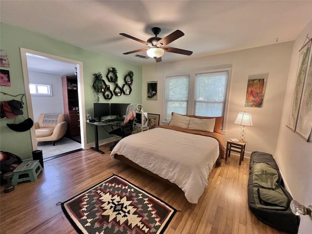 bedroom with light wood-type flooring, visible vents, baseboards, and ceiling fan
