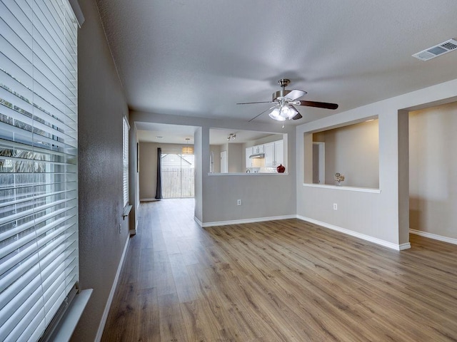 6709 Doyal Dr, Austin, TX 78747 - unfurnished living room featuring wood finished floors, ceiling fan, and baseboards