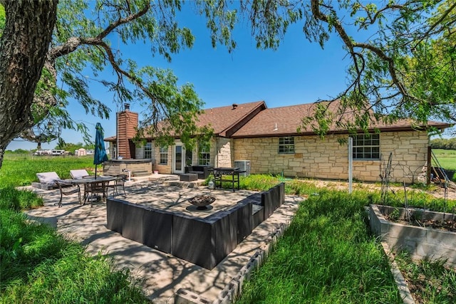 358 Easley Rd, Smithville, TX 78957 - back of property featuring a patio area, a chimney, stone siding, and central AC unit