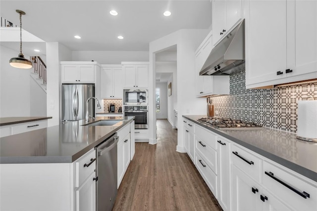 2616 War Wagon Way, Leander, TX 78641 - kitchen with under cabinet range hood, appliances with stainless steel finishes, dark countertops, a sink, and recessed lighting