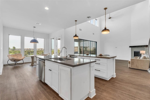 2616 War Wagon Way, Leander, TX 78641 - kitchen featuring a kitchen island with sink, dark countertops, stainless steel dishwasher, dark wood-type flooring, and recessed lighting