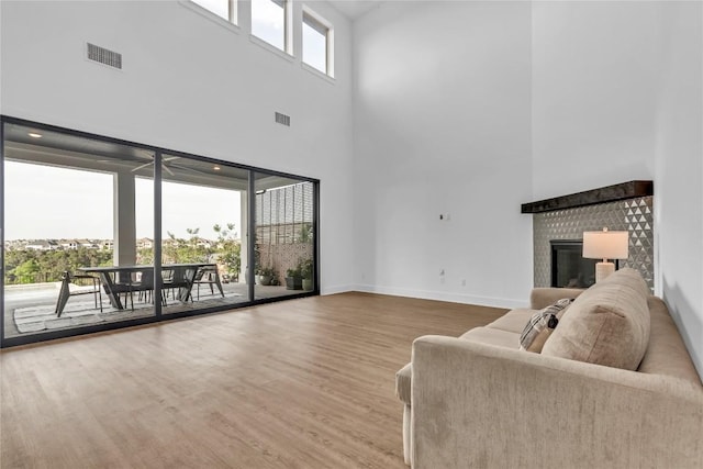 2616 War Wagon Way, Leander, TX 78641 - living area with a towering ceiling, wood finished floors, a brick fireplace, and baseboards