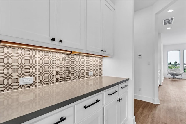 2616 War Wagon Way, Leander, TX 78641 - kitchen with wood finished floors, decorative backsplash, white cabinets, dark countertops, and recessed lighting