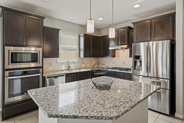 5679 Corsica Loop, Round Rock, TX 78665 - kitchen with stainless steel appliances, dark brown cabinetry, light tile patterned floors, light stone countertops, and under cabinet range hood