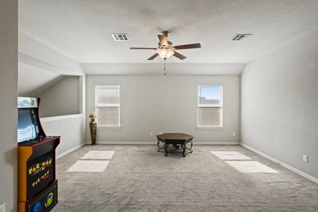 5679 Corsica Loop, Round Rock, TX 78665 - playroom with ceiling fan, carpet flooring, lofted ceiling, healthy amount of natural light, and a textured ceiling