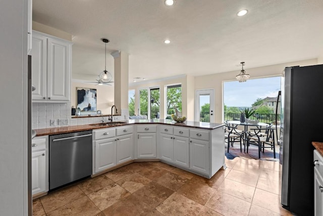 10012 Scull Creek Dr, Austin, TX 78730 - kitchen featuring appliances with stainless steel finishes, a sink, white cabinets, recessed lighting, and a peninsula
