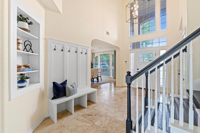10012 Scull Creek Dr, Austin, TX 78730 - mudroom with arched walkways, a chandelier, a towering ceiling, and light tile patterned flooring