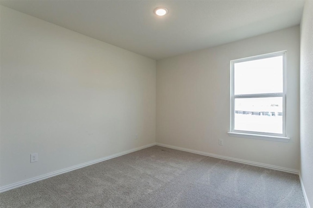 unfurnished room with baseboards, carpet flooring, and a healthy amount of sunlight