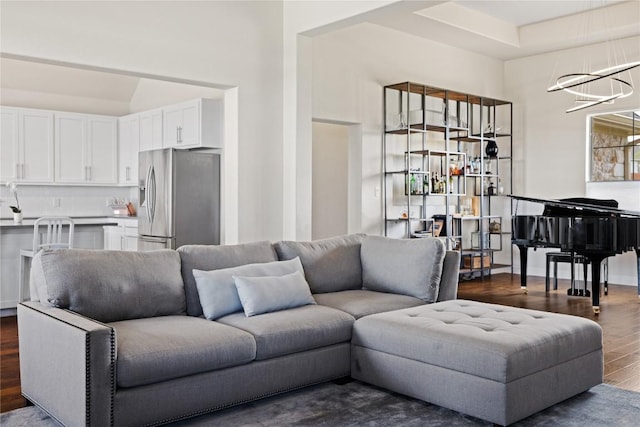 living room featuring a chandelier and dark wood-style flooring