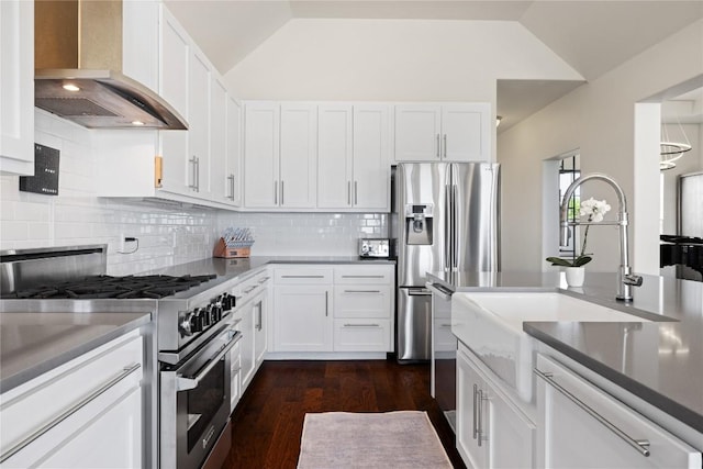 kitchen featuring white cabinets, wall chimney exhaust hood, appliances with stainless steel finishes, and backsplash