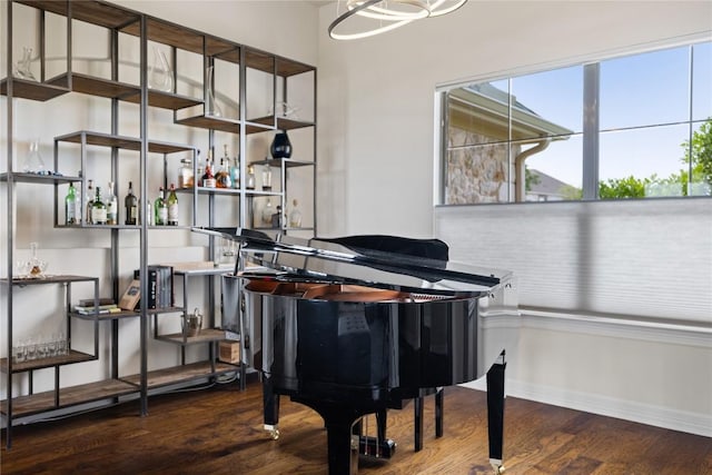 living area featuring baseboards, wood finished floors, and a bar