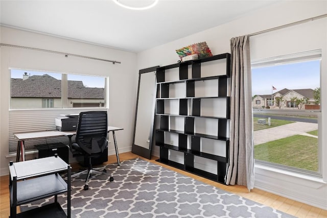 home office with baseboards, wood finished floors, and a wealth of natural light
