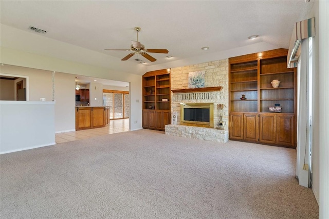 21407 High Dr, Lago Vista, TX 78645 - unfurnished living room with a ceiling fan, lofted ceiling, built in shelves, a fireplace, and light colored carpet