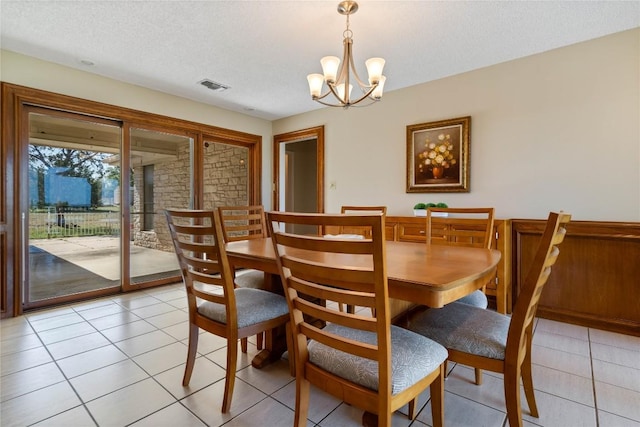 21407 High Dr, Lago Vista, TX 78645 - dining space featuring a chandelier, a textured ceiling, and light tile patterned floors
