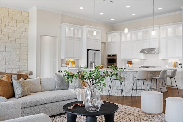 2325 High Lonesome, Leander, TX 78641 - living area featuring wood finished floors, crown molding, a towering ceiling, and recessed lighting