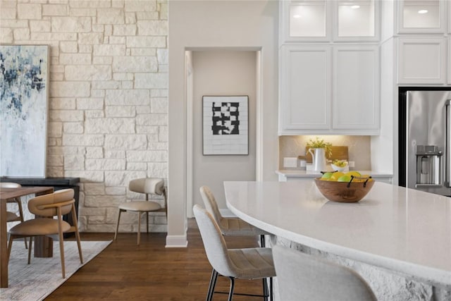 2325 High Lonesome, Leander, TX 78641 - kitchen with stainless steel fridge, white cabinetry, a kitchen bar, light countertops, and glass insert cabinets