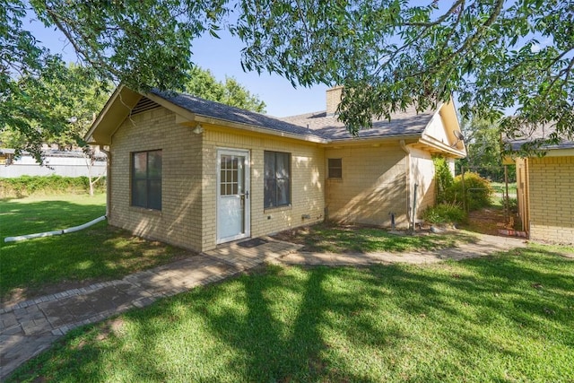 168 Bastrop St, Mcdade, TX 78650 - rear view of property featuring brick siding, a lawn, and a chimney