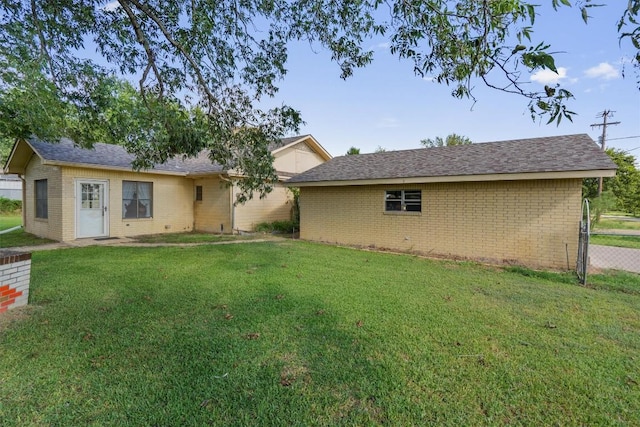 168 Bastrop St, Mcdade, TX 78650 - rear view of house with fence, a shingled roof, brick siding, and a yard