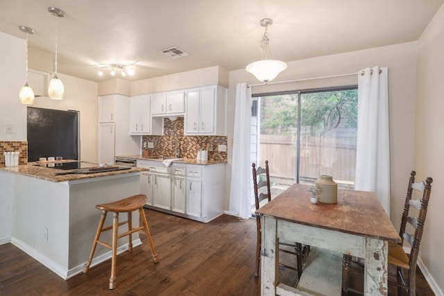 5604 Woodrow Ave Unit 7, Austin, TX 78756 - kitchen with black electric cooktop, decorative backsplash, dark wood-style flooring, and white cabinets
