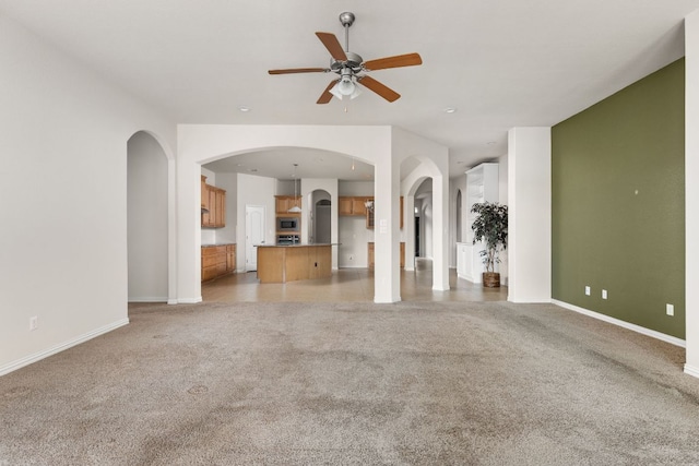 217 Monahans Dr, Georgetown, TX 78628 - unfurnished living room featuring light carpet, ceiling fan, and arched walkways