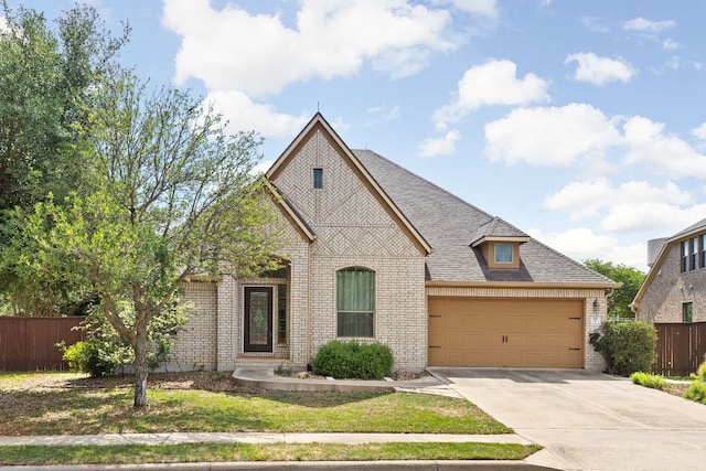 217 Monahans Dr, Georgetown, TX 78628 - french country inspired facade featuring brick siding, concrete driveway, an attached garage, and roof with shingles