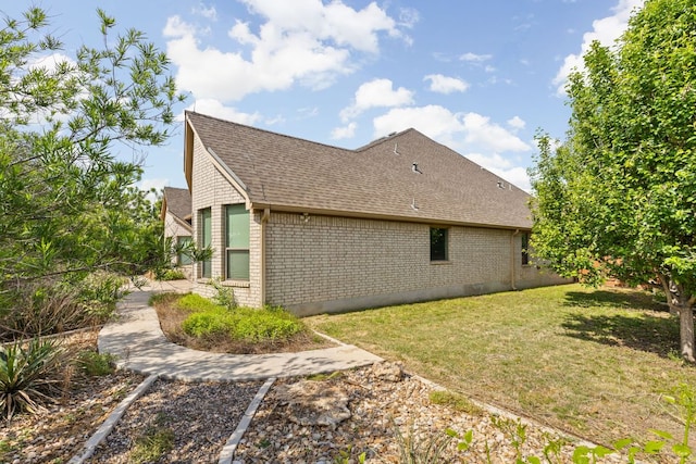217 Monahans Dr, Georgetown, TX 78628 - view of side of property featuring brick siding, roof with shingles, and a lawn