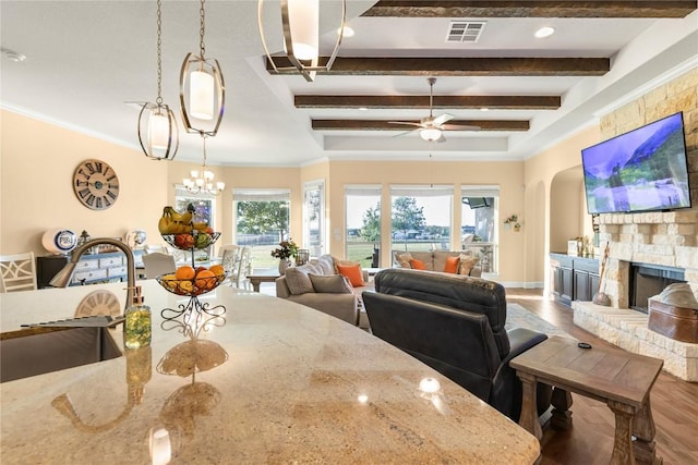 2560 Square Nail Cv, Leander, TX 78641 - dining room featuring wood finished floors, ceiling fan, a fireplace, beamed ceiling, and arched walkways
